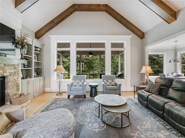 living room with high vaulted ceiling, a fireplace, light hardwood / wood-style floors, and beamed ceiling