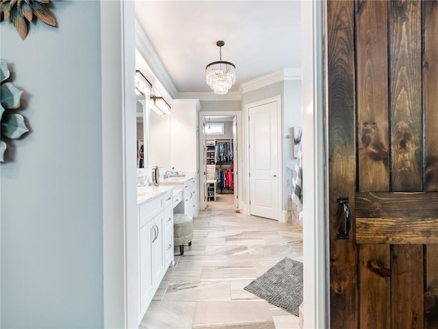 bathroom with vanity, crown molding, and a chandelier