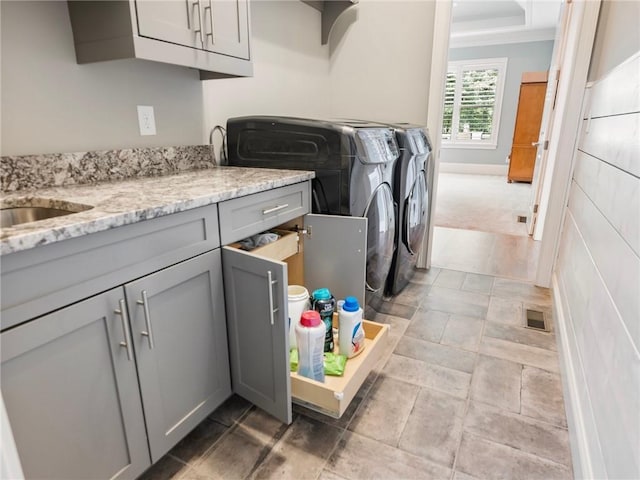 laundry room with cabinets, washer and clothes dryer, and sink