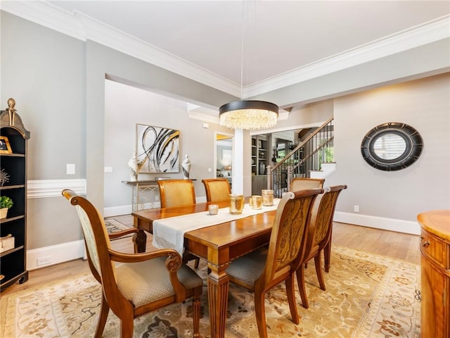 dining space featuring an inviting chandelier, crown molding, and light hardwood / wood-style flooring