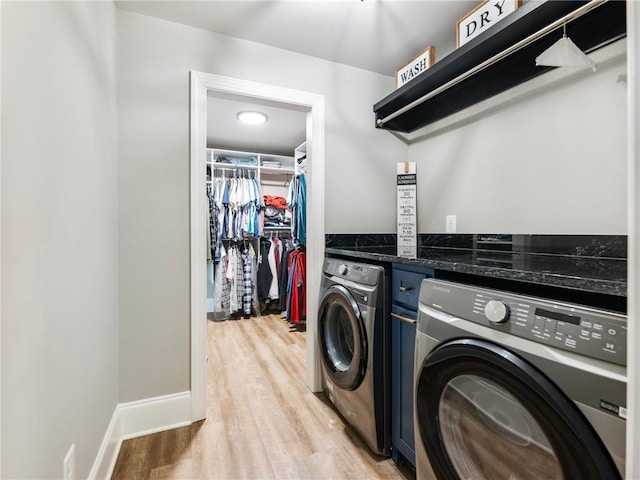 clothes washing area featuring independent washer and dryer and light hardwood / wood-style flooring