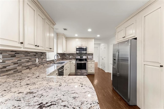 185 Lee Path, Acworth, GA 30102 - kitchen with stainless steel appliances, tasteful backsplash, cream cabinetry, light stone countertops, and recessed lighting