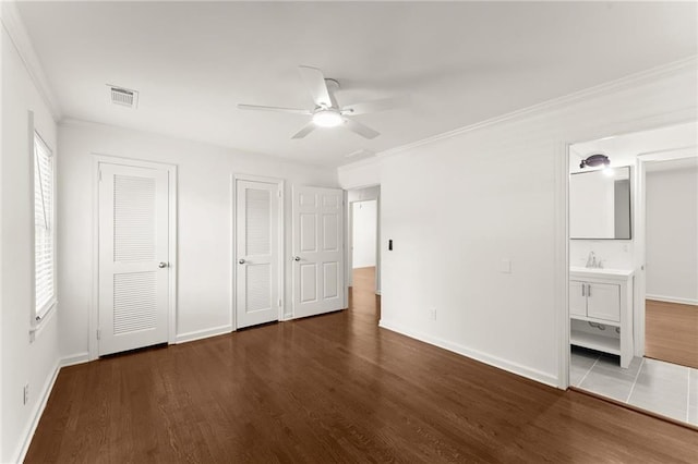 185 Lee Path, Acworth, GA 30102 - unfurnished bedroom with two closets, wood finished floors, ornamental molding, connected bathroom, and ceiling fan
