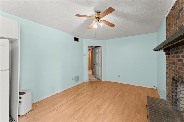 185 Lee Path, Acworth, GA 30102 - unfurnished living room with a brick fireplace, light wood-style floors, ceiling fan, and a textured ceiling