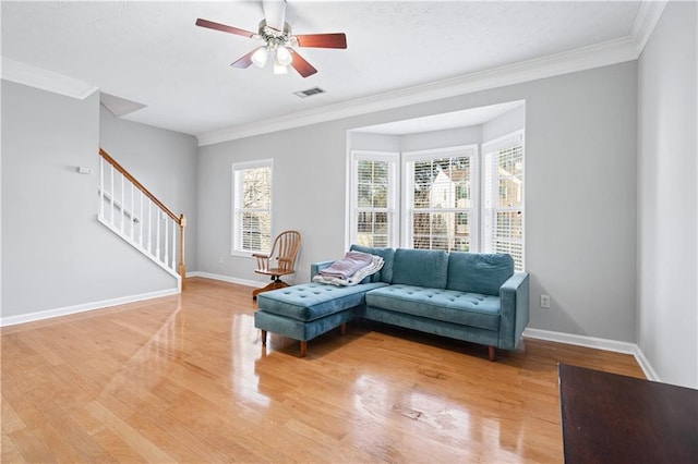 living room with hardwood / wood-style flooring, ceiling fan, and crown molding