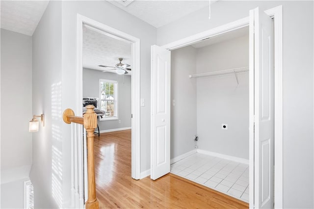 clothes washing area featuring hardwood / wood-style floors, hookup for an electric dryer, a textured ceiling, and ceiling fan