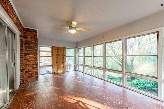 unfurnished living room with ceiling fan and a textured ceiling