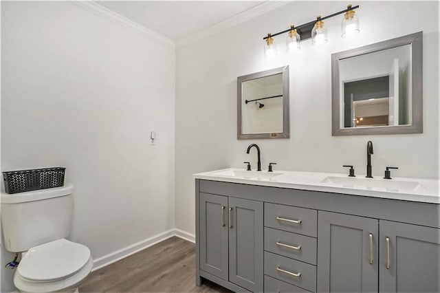 full bath with toilet, wood finished floors, baseboards, and a sink