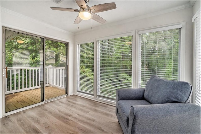 sunroom with wood finished floors and ornamental molding