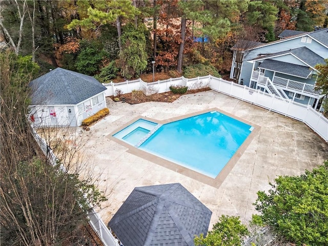 view of pool featuring a patio area, a pool with connected hot tub, and a fenced backyard