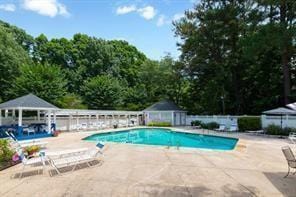 pool with a gazebo, fence, and a patio