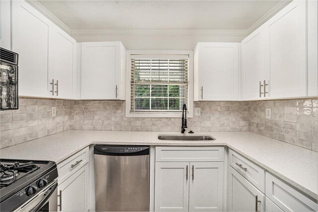 kitchen with a sink, stainless steel appliances, ornamental molding, backsplash, and white cabinets