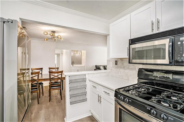 kitchen with light wood finished floors, white cabinetry, decorative backsplash, light countertops, and appliances with stainless steel finishes