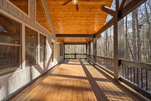 unfurnished sunroom featuring vaulted ceiling with beams, wood ceiling, and ceiling fan