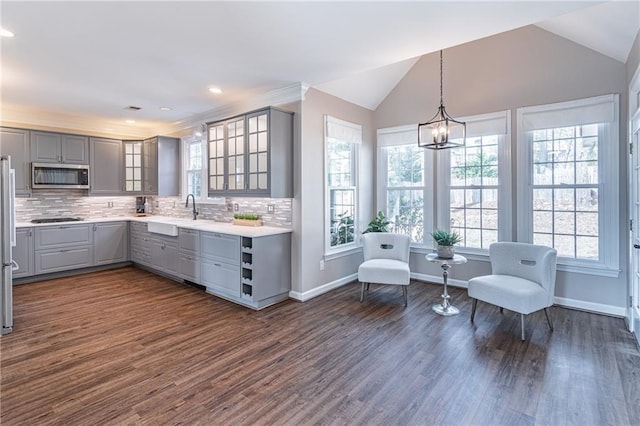 kitchen with appliances with stainless steel finishes, decorative light fixtures, sink, gray cabinetry, and decorative backsplash