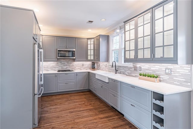 kitchen with tasteful backsplash, appliances with stainless steel finishes, sink, and gray cabinetry