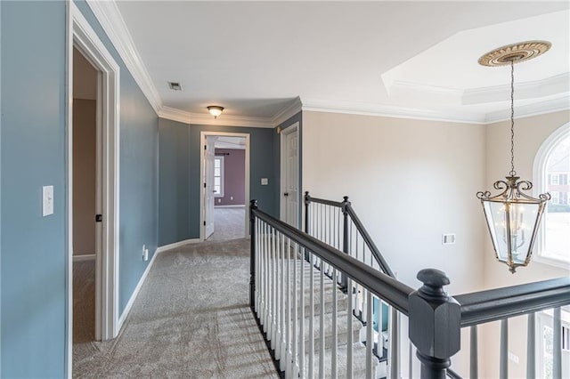 hallway featuring ornamental molding, carpet, and a notable chandelier