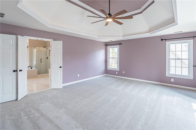 unfurnished bedroom with crown molding, connected bathroom, a raised ceiling, and light carpet