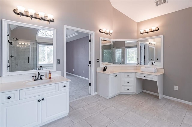 bathroom featuring lofted ceiling, vanity, and plenty of natural light