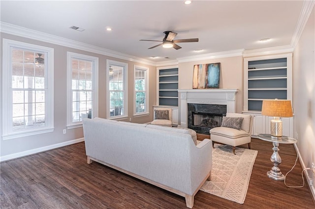 living room with dark wood-type flooring, ornamental molding, and a fireplace