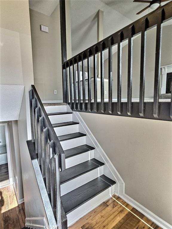 stairs with baseboards and wood finished floors