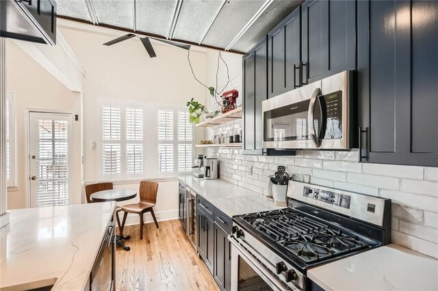 1078 Piedmont Ave NE Unit 206, Atlanta, GA 30309 - kitchen with appliances with stainless steel finishes, wine cooler, open shelves, backsplash, and blue cabinetry