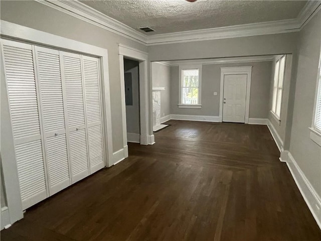 foyer entrance with a textured ceiling, ornamental molding, and dark hardwood / wood-style floors