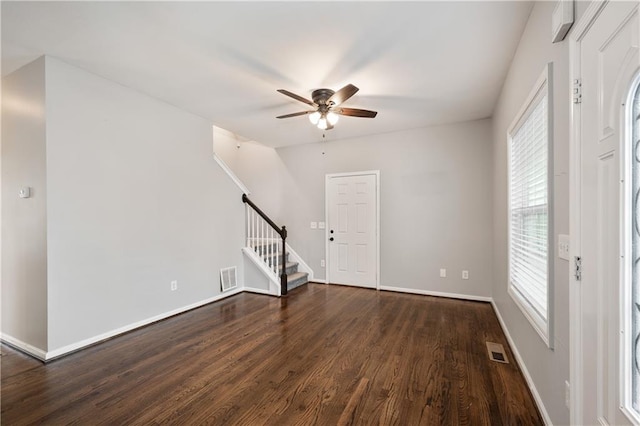 spare room with ceiling fan, a wealth of natural light, and dark hardwood / wood-style flooring