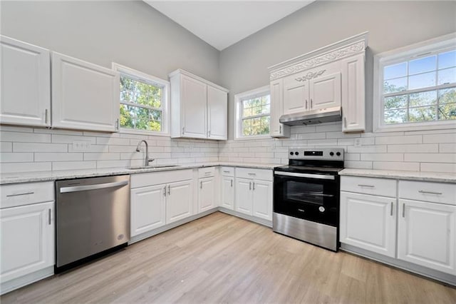 kitchen featuring backsplash, sink, stainless steel appliances, white cabinets, and light stone counters