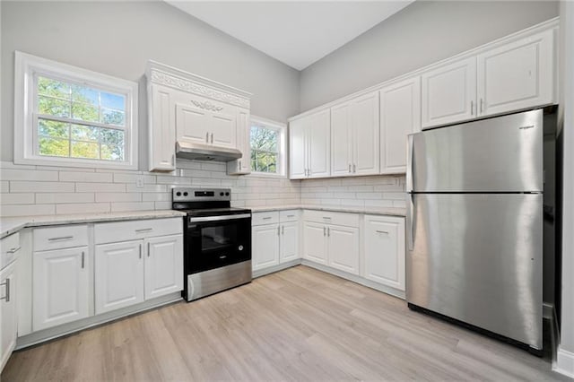 kitchen featuring white cabinets, light hardwood / wood-style flooring, stainless steel appliances, and tasteful backsplash