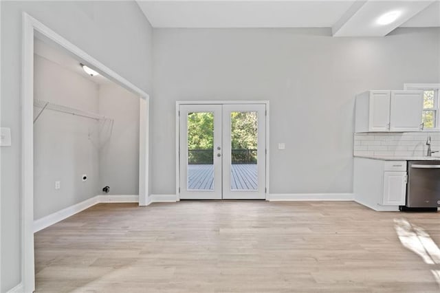 unfurnished living room with french doors and light wood-type flooring