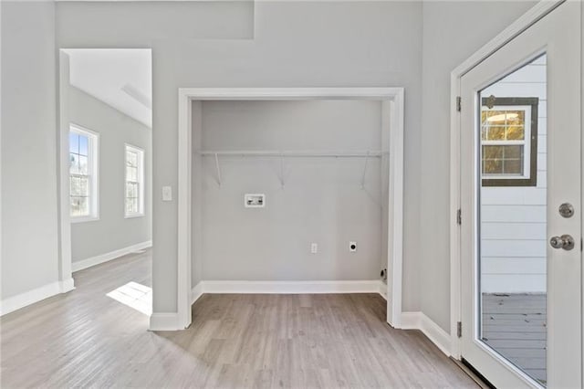 laundry area with light wood-type flooring, hookup for a washing machine, and hookup for an electric dryer