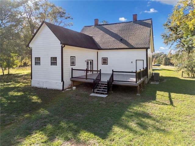 back of property with central AC unit, a deck, and a yard