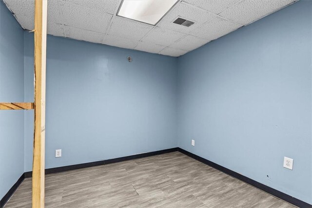 843 Mcafee St, Dalton, GA 30721 - empty room featuring wood finished floors, visible vents, a drop ceiling, and baseboards