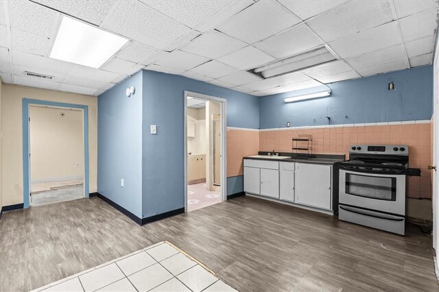 843 Mcafee St, Dalton, GA 30721 - kitchen with white cabinets, wood finished floors, visible vents, stainless steel electric range, and a paneled ceiling