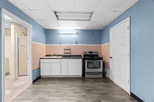 843 Mcafee St, Dalton, GA 30721 - kitchen featuring wood finished floors, a sink, stainless steel electric range oven, a drop ceiling, and white cabinetry