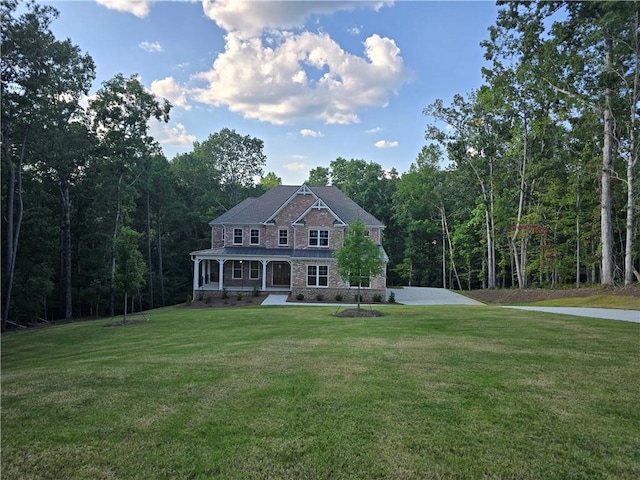 view of front facade with a wooded view and a front lawn