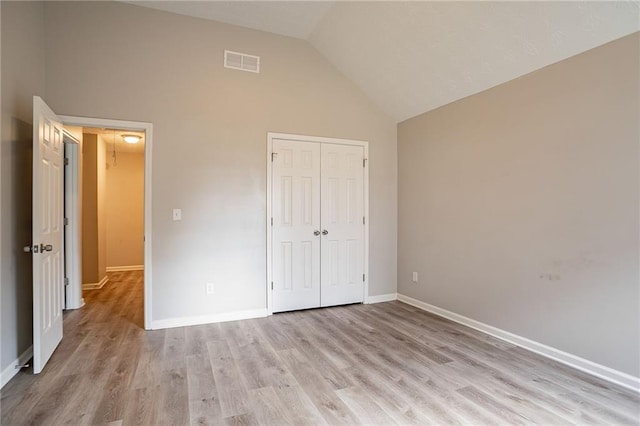 11143 Aliyah Dr, Hampton, GA 30228 - unfurnished bedroom with light wood-type flooring, visible vents, high vaulted ceiling, a closet, and baseboards