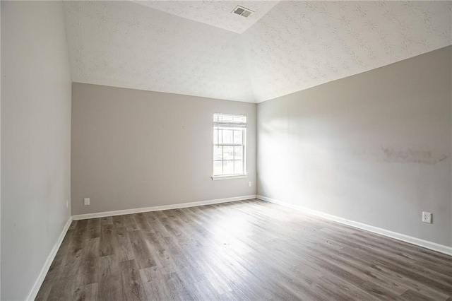 11143 Aliyah Dr, Hampton, GA 30228 - spare room featuring visible vents, baseboards, wood finished floors, and vaulted ceiling