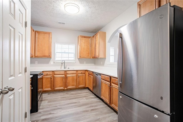 11143 Aliyah Dr, Hampton, GA 30228 - kitchen featuring visible vents, light wood finished floors, a sink, light countertops, and appliances with stainless steel finishes