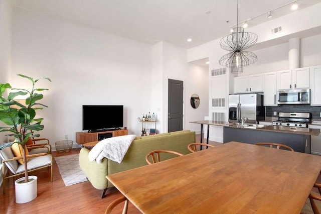 1195 Milton Ter SE Unit 1407, Atlanta, GA 30315 - dining room with light wood finished floors, a towering ceiling, and rail lighting