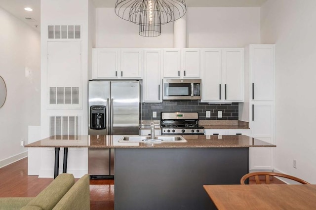 1195 Milton Ter SE Unit 1407, Atlanta, GA 30315 - kitchen with stainless steel appliances, white cabinets, decorative backsplash, dark wood finished floors, and a sink