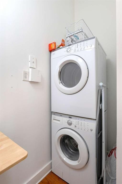 1195 Milton Ter SE Unit 1407, Atlanta, GA 30315 - laundry room with stacked washing machine and dryer, baseboards, and wood finished floors