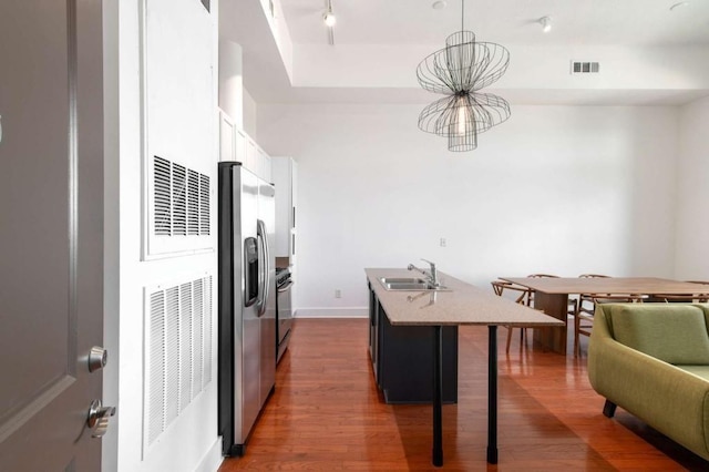1195 Milton Ter SE Unit 1407, Atlanta, GA 30315 - kitchen featuring stainless steel fridge, a sink, wood finished floors, a kitchen breakfast bar, and an island with sink