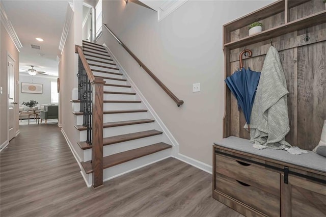 staircase with wood-type flooring and ornamental molding