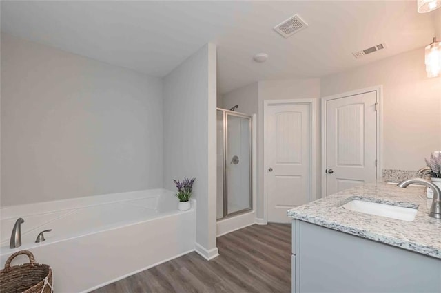 bathroom with vanity, shower with separate bathtub, and hardwood / wood-style floors