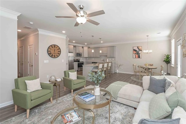 living room featuring wood-type flooring, ceiling fan with notable chandelier, and crown molding