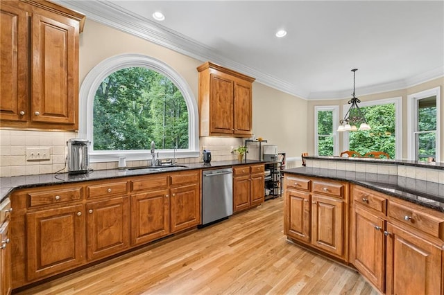 kitchen with stainless steel dishwasher, a sink, brown cabinetry, light wood-style flooring, and tasteful backsplash