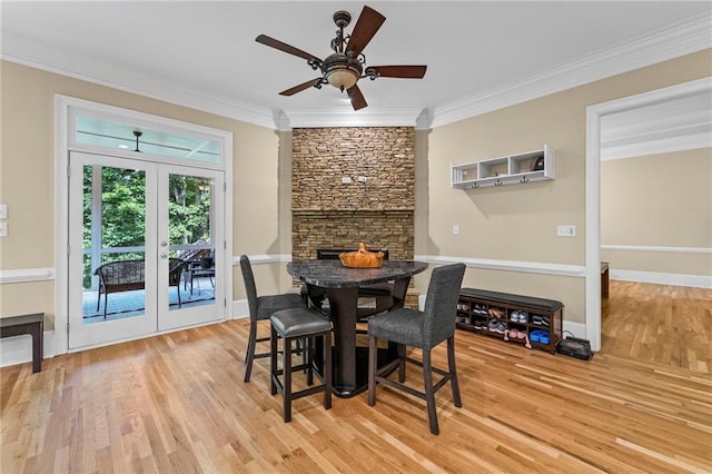dining space featuring wood finished floors, ornamental molding, french doors, ceiling fan, and baseboards