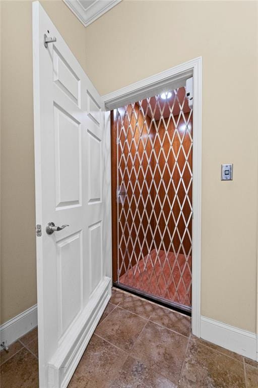 elevator with crown molding and baseboards